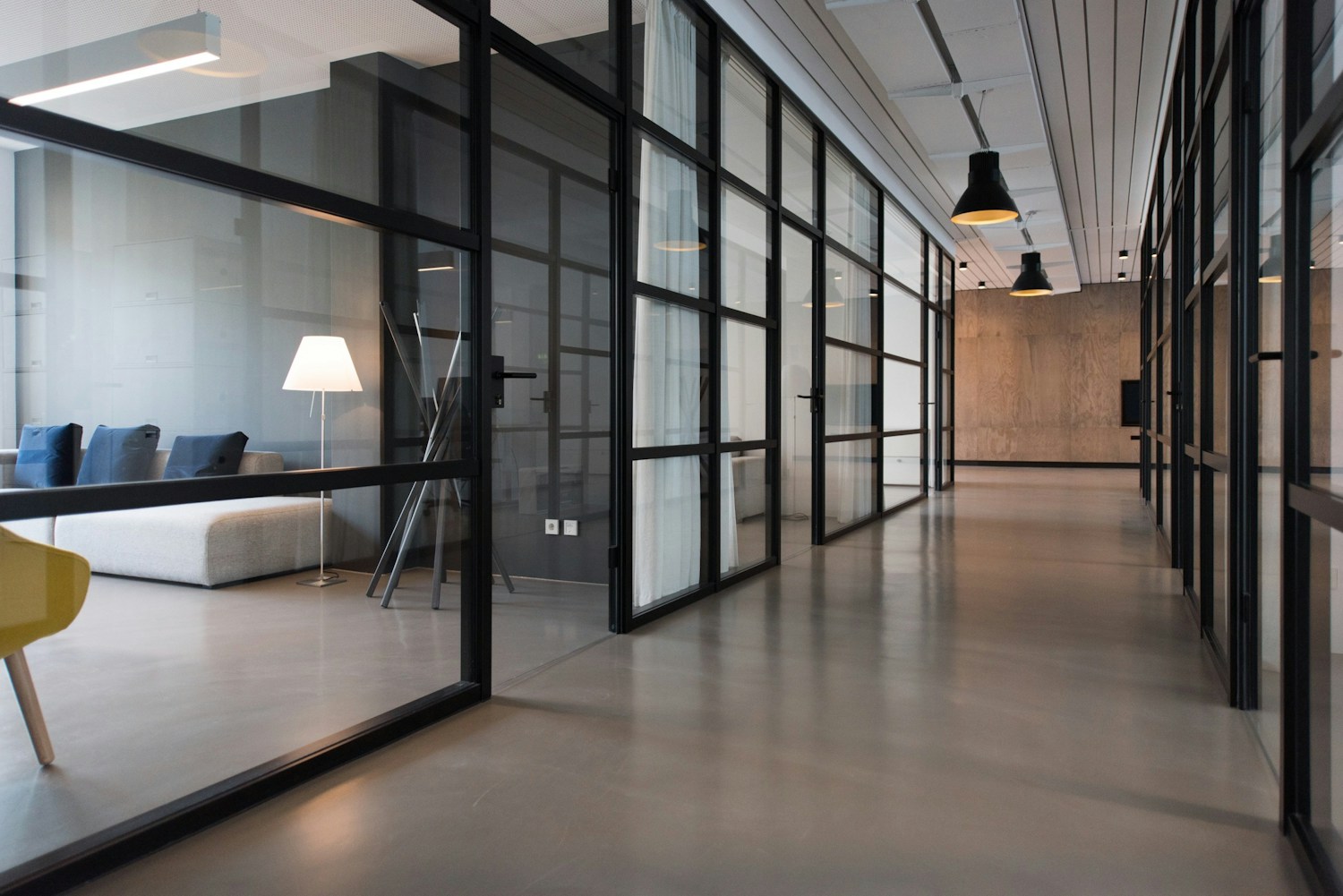 Interior de un espacio de trabajo contemporáneo con divisiones de cristal